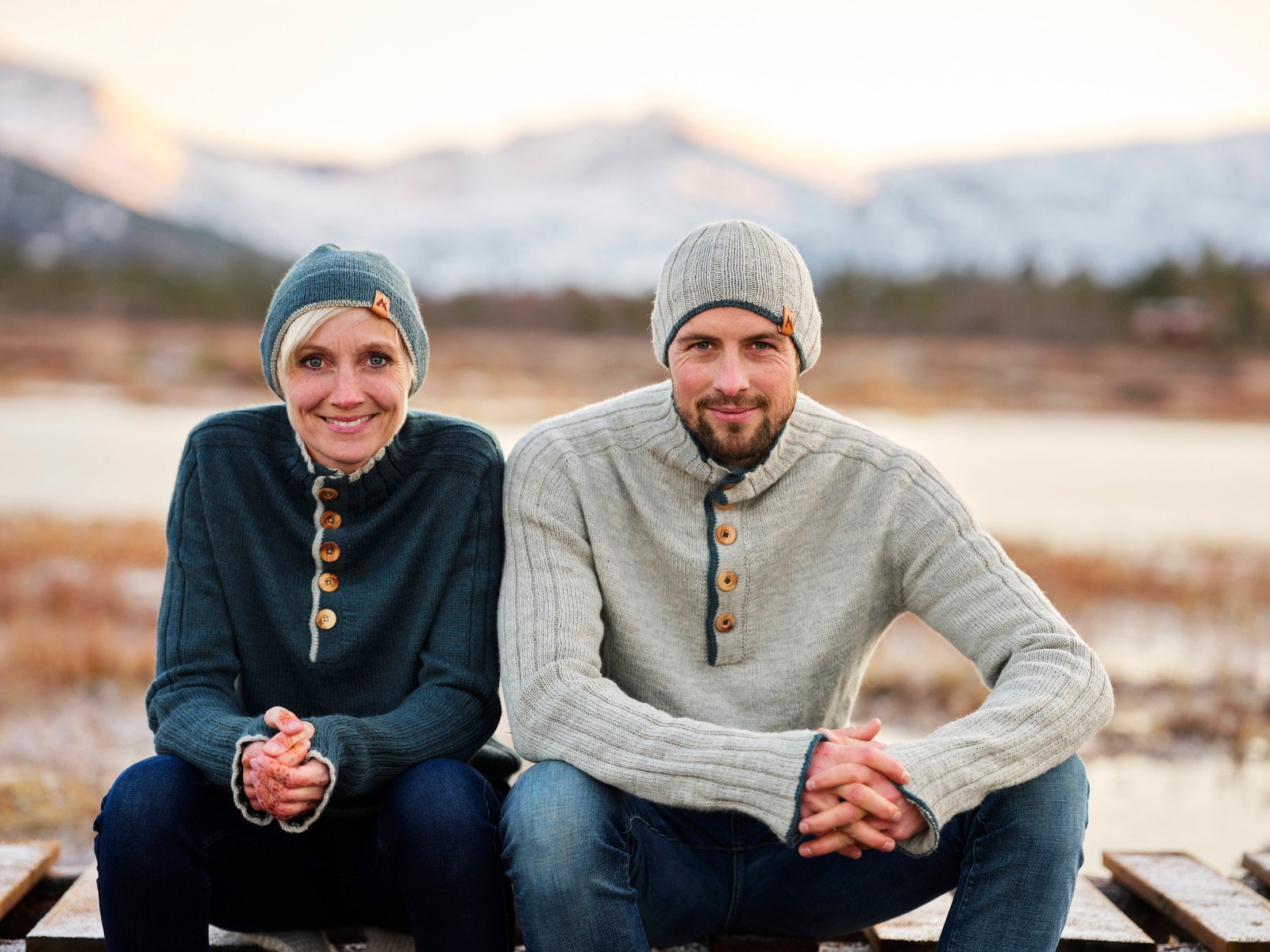 Gøran Bolme og Åse Børset sitter ved vannet med fjellene i Trollheimen bak seg